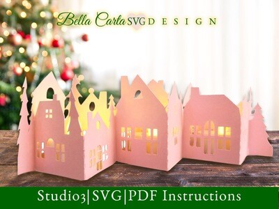 DIY holiday centerpiece made of cardstock that resembles a snowy village with pine trees.