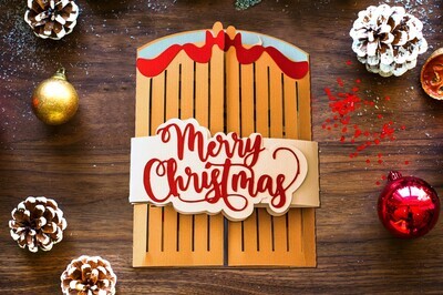 Christmas Card 3D SVG template for Cricut and Silhouette depicting gates that open to reveal a snow-covered cottage nestled in a winter forest.  The card comes with two belly bands that say Happy Christmas or Merry Christmas.