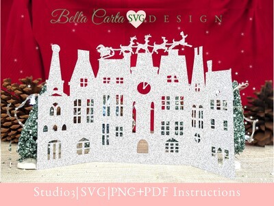 Finished 3D Christmas card using an SVG template with a Cricut or Silhouette is in the shape of a Victorian village at midnight when Santa and his reindeer fly over, delivering presents to all the children.   Shown here in silver glitter cardstock.