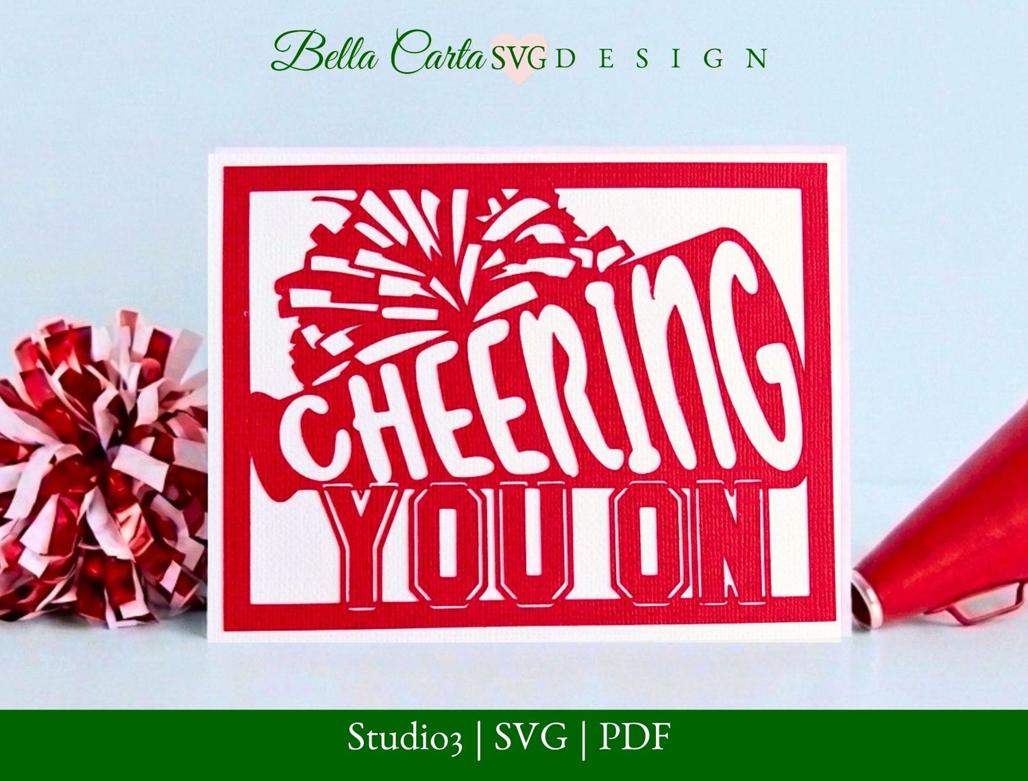 3D layered paper card featuring a cheerleader megaphone, pom-poms, and the words 'Cheering You On.' Designed as a layered SVG