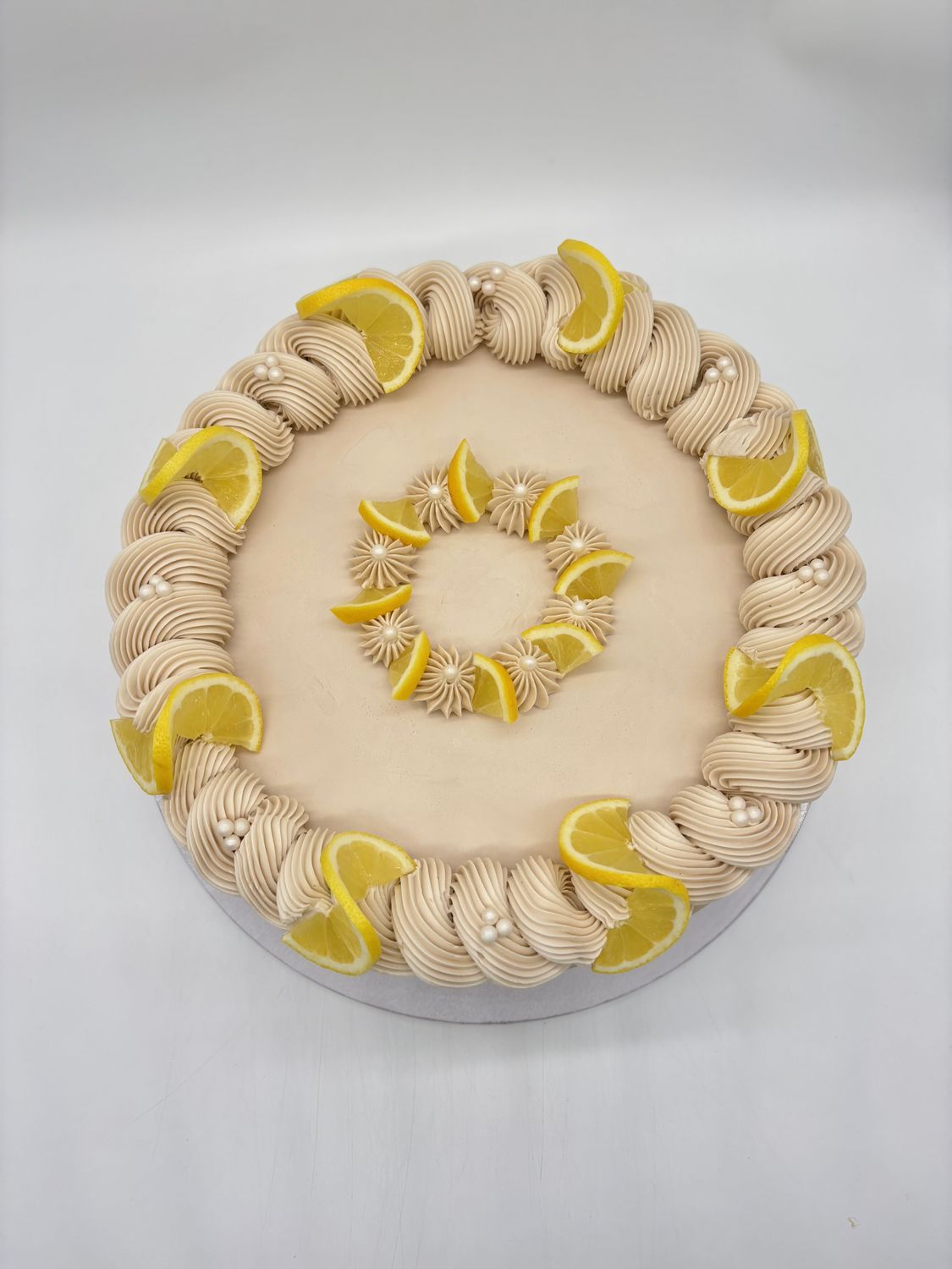 Torte mit Cremedekoration und Zitronen