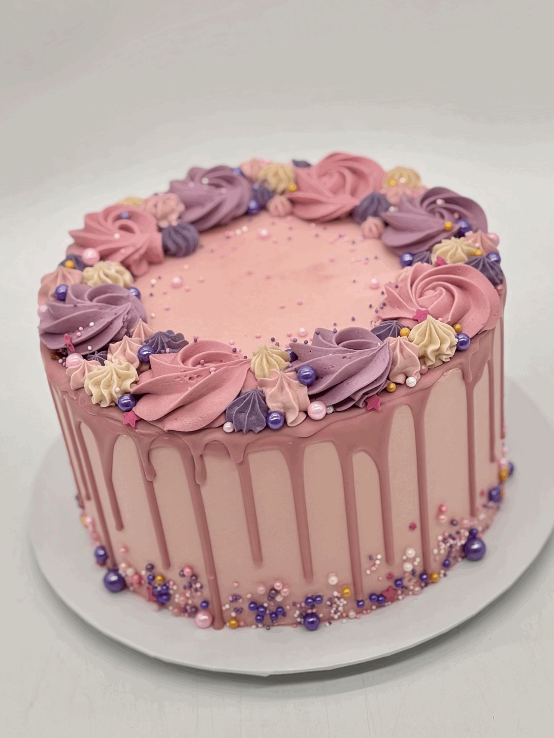 Torte mit Drip, Cremerosen und Perlendekoration