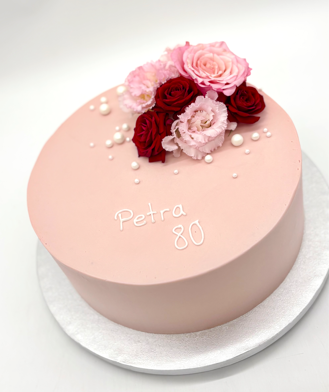 Torte mit Blumendekoration und Perlen