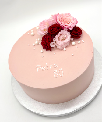 Torte mit Blumendekoration und Perlen