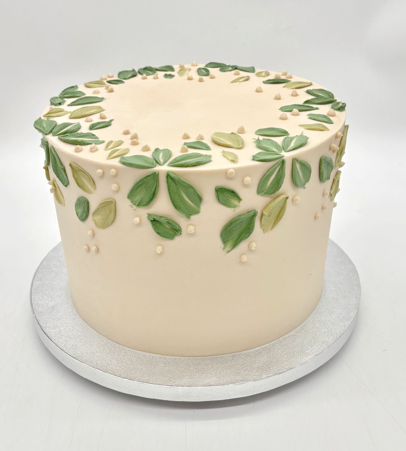 Torte mit Cremeblättern und Punkten