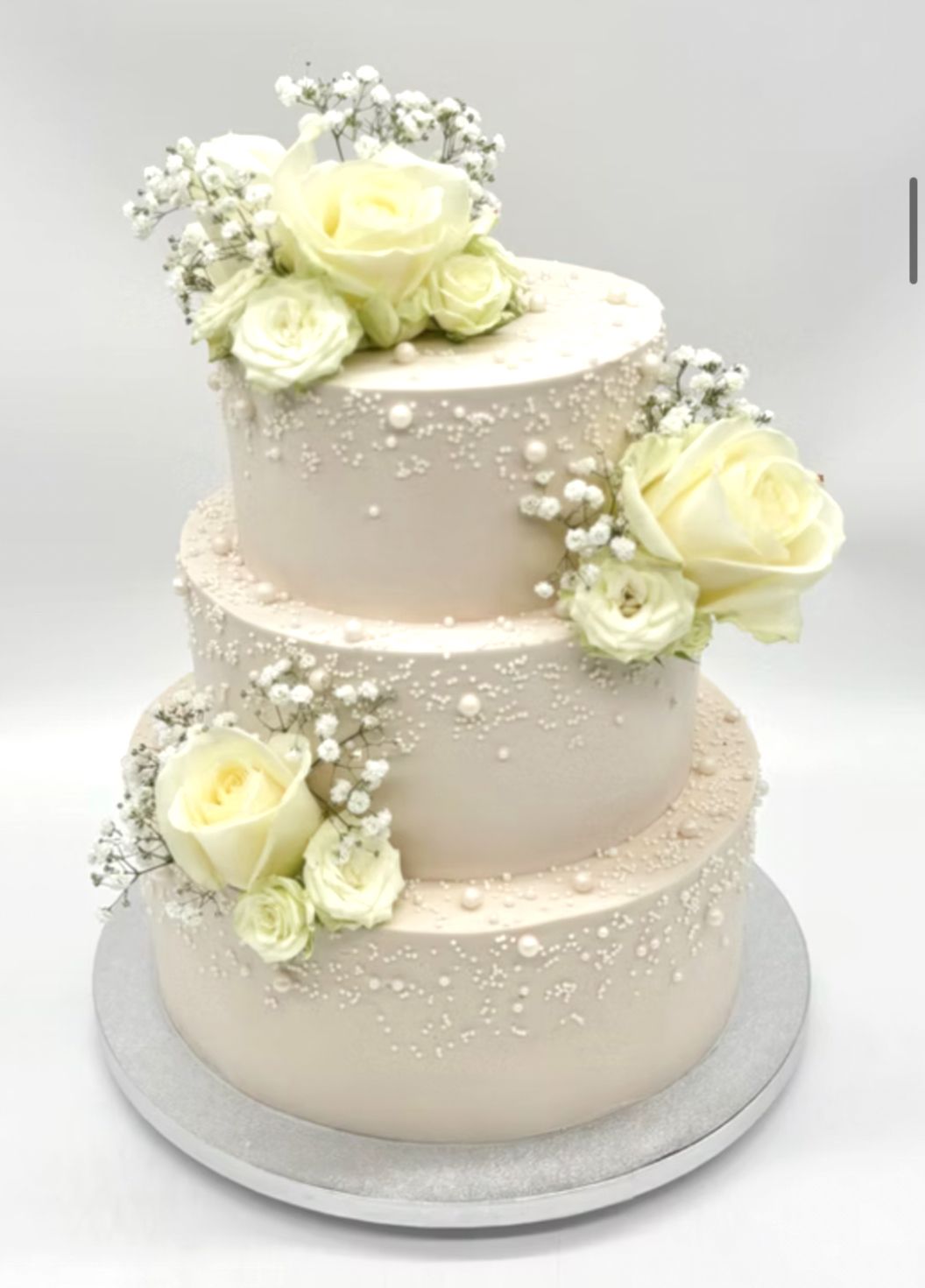 Torte mit Perlendekoration und weißen Blumen (dreistöckig)