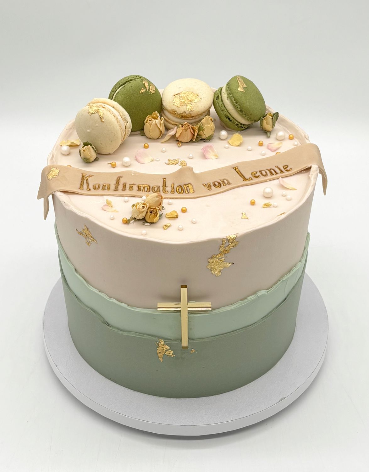 Torte mit aufgesetzten Cremerändern, 3 Macarons, essbaren Blüten, Kreuz und Banderole