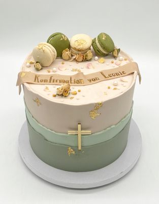 Torte mit aufgesetzten Cremerändern, 3 Macarons, essbaren Blüten, Kreuz und Banderole