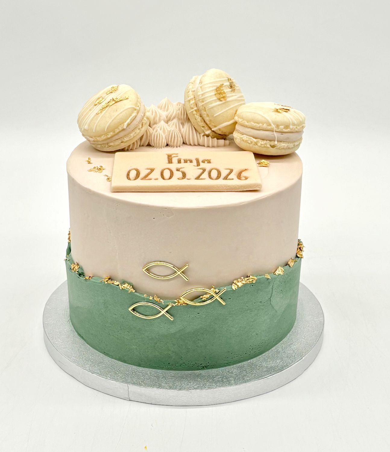 Torte mit aufgesetzten Cremerändern, 3 Macarons, 3 Fischen und Blattgold