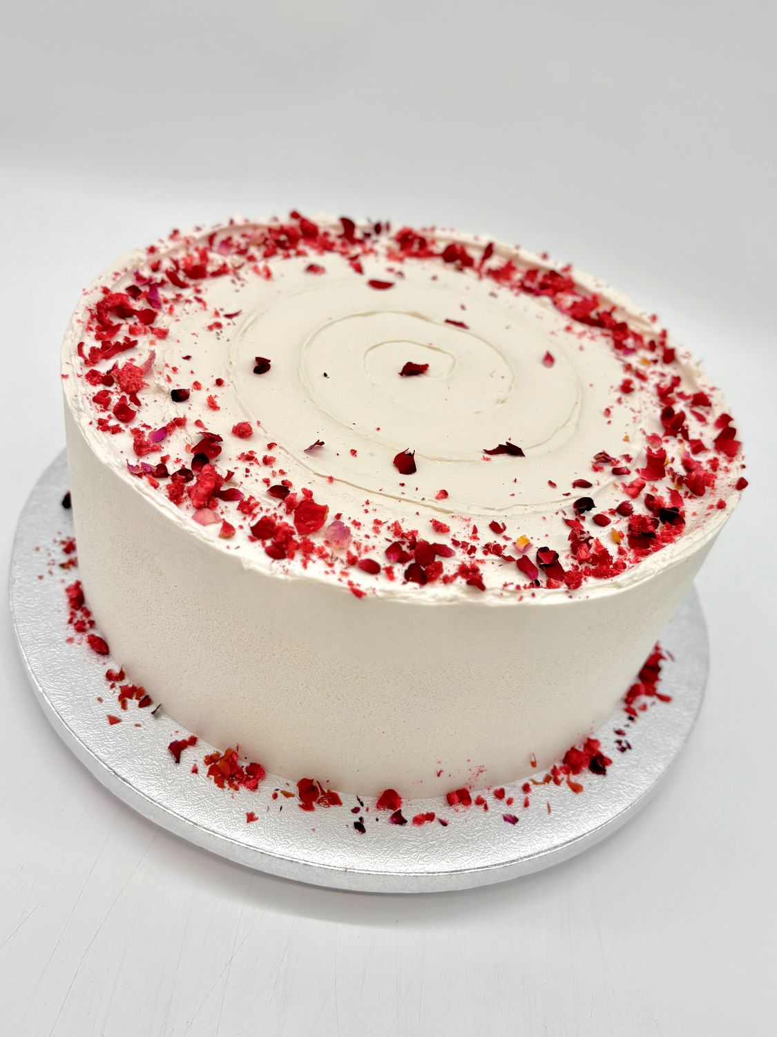 Torte mit Spirale und Dekoration aus getrockneten Früchten und essbaren Blüten