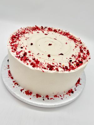 Torte mit Spirale und Dekoration aus getrockneten Früchten und essbaren Blüten