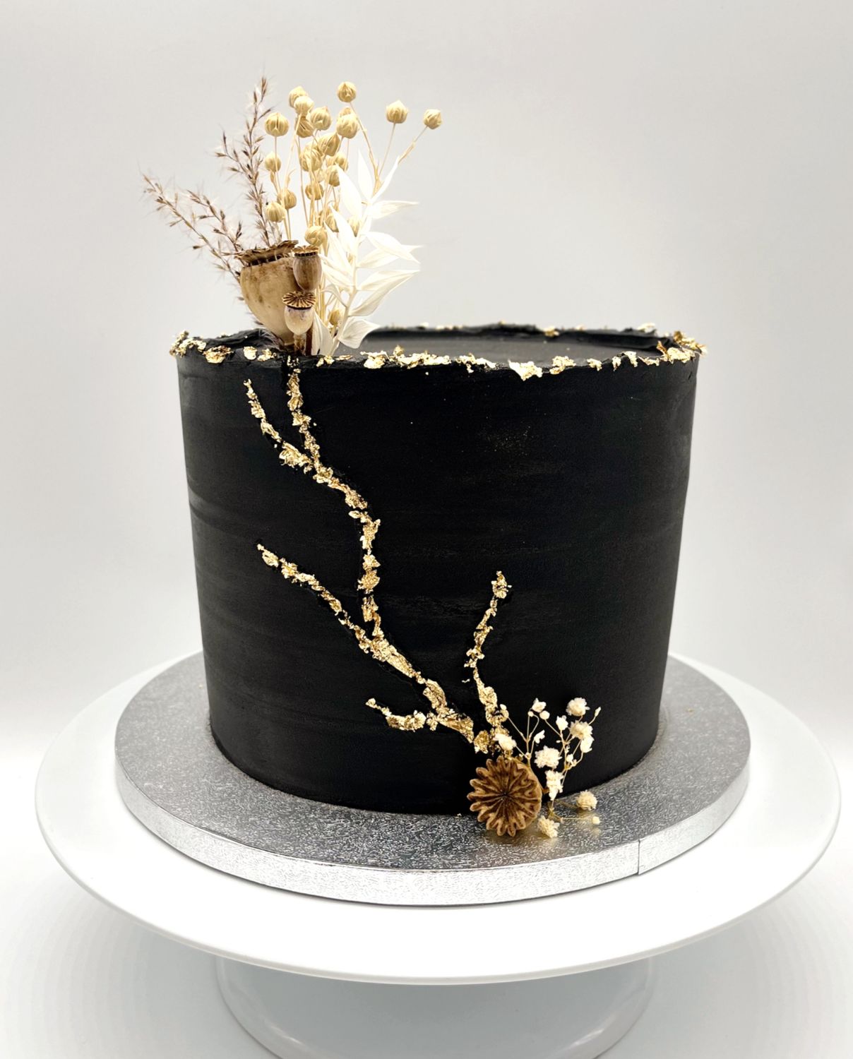 Torte schwarz/gold mit goldbesetzten Rissen und Trockenblumen