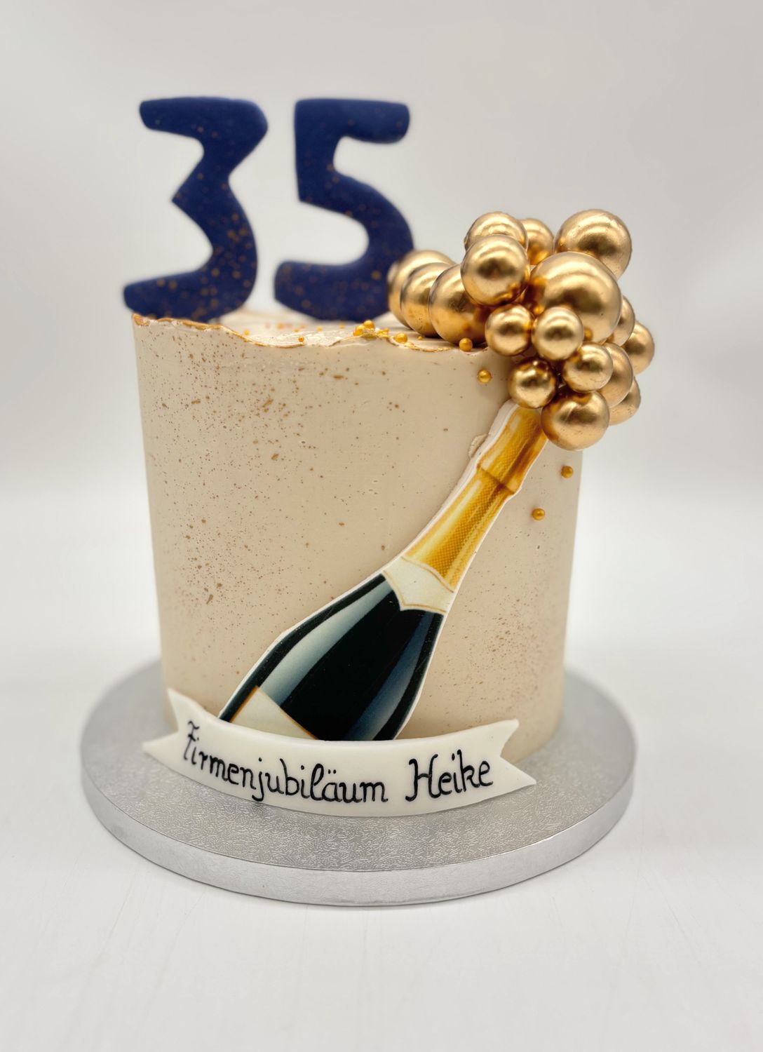 Torte "Sektflasche" mit Goldspritzern und Kugeln