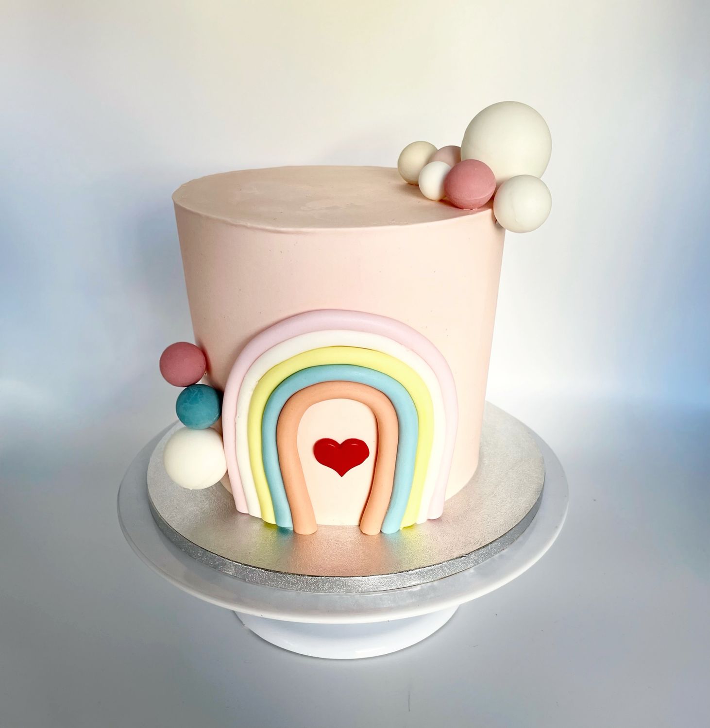 Torte Regenbogen mit Herz und Kugeln