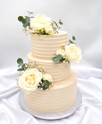 Torte mit gleichmäßiger Rillenoptik und weißen Blumen (dreistöckig)