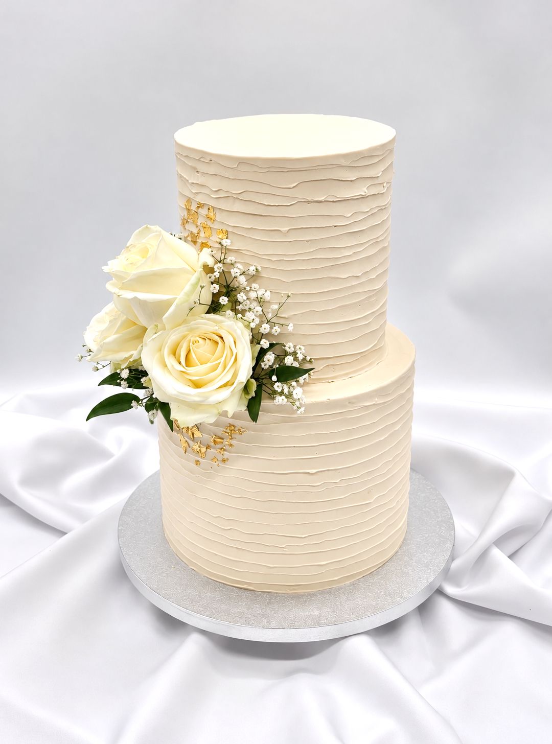 Torte mit unregelmäßiger Rillenoptik, Blumen und Blattgold zweistöckig