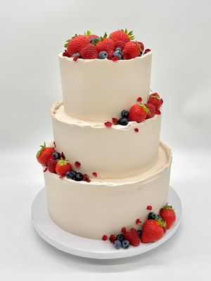 Torte mit akzentuierter Früchtedekoration und essbaren Rosenblüten (dreistöckig)