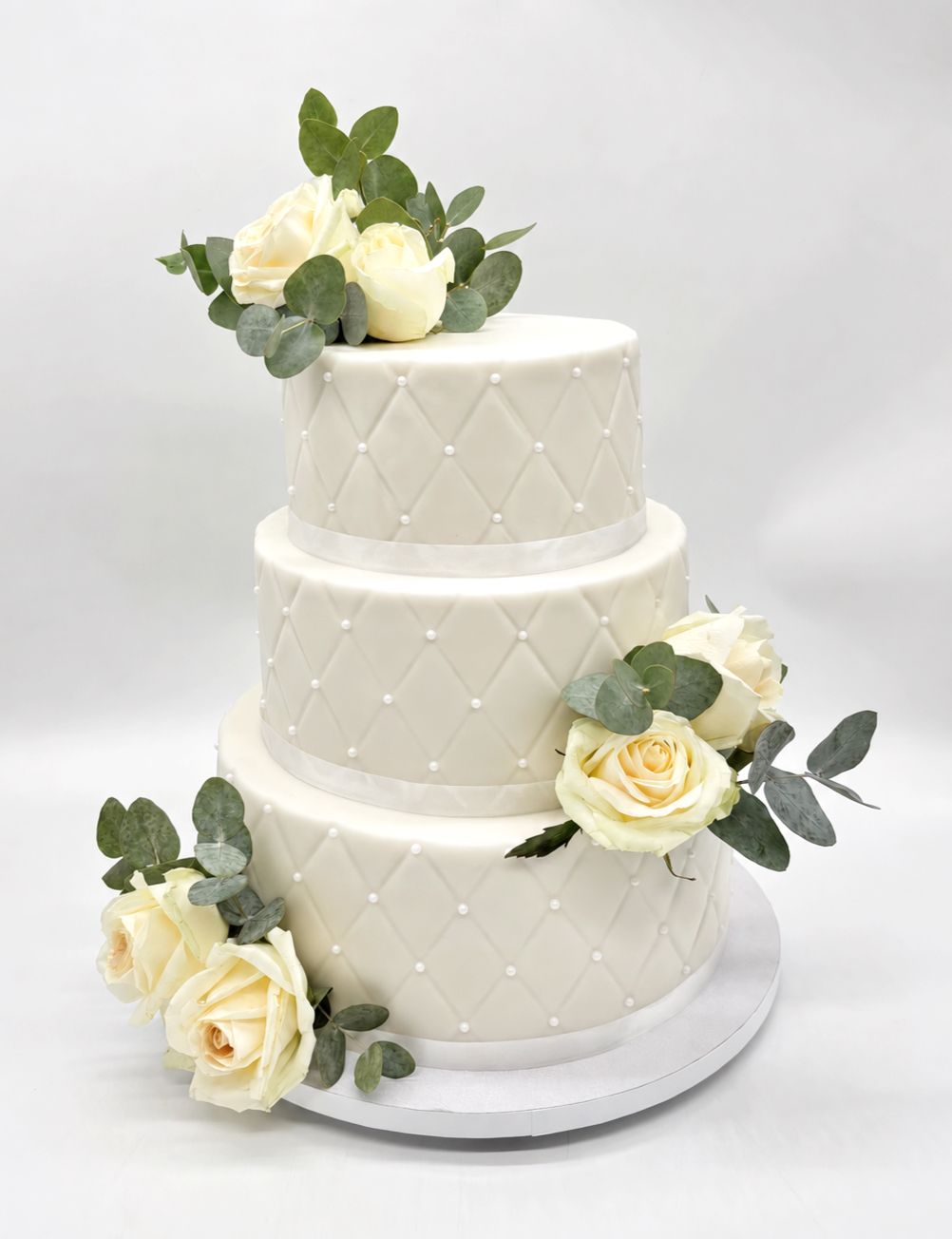 Torte mit Fondantüberzug, Rautenoptik und Blumen (dreistöckig)