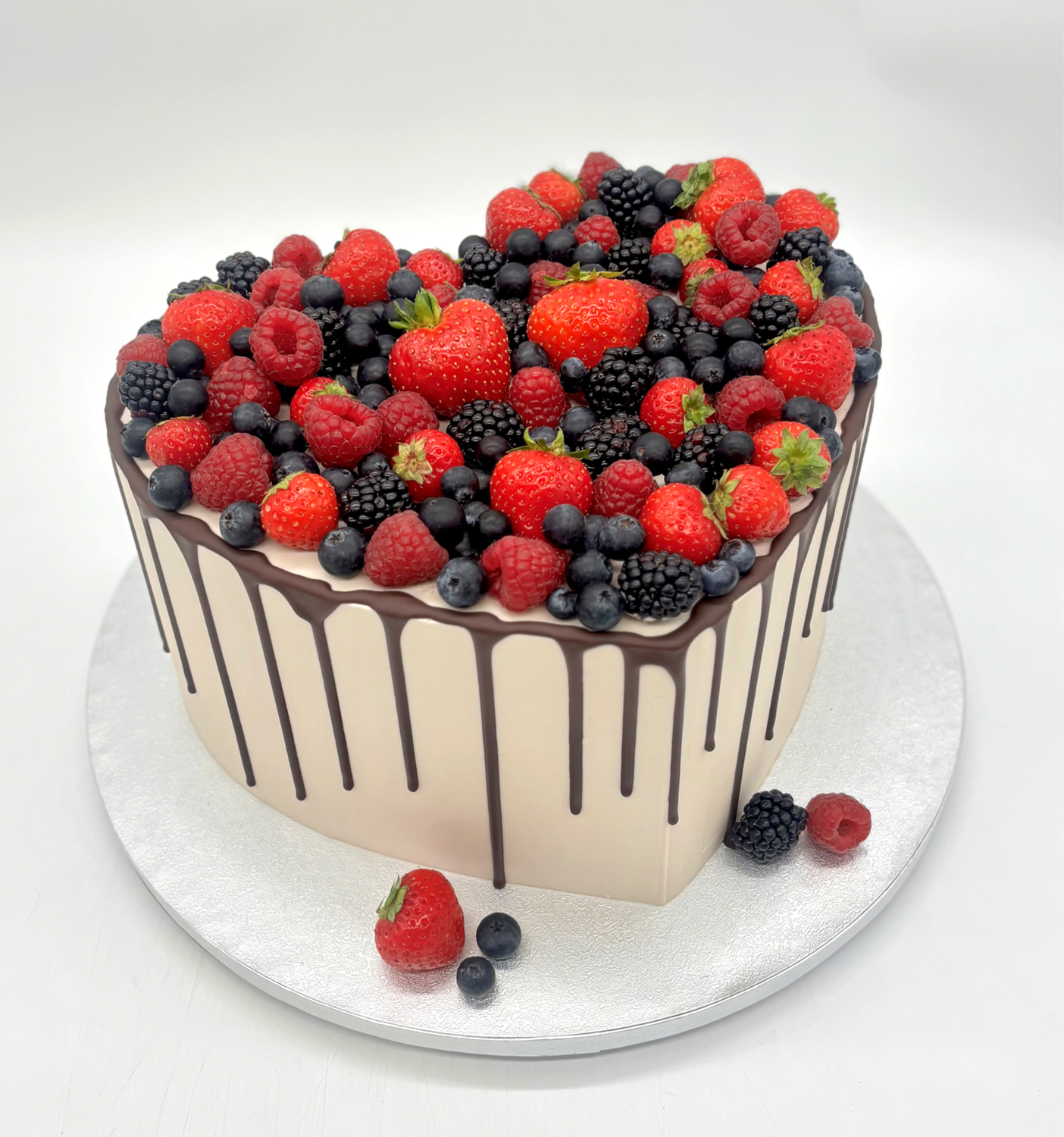 Torte Herzform mit Schokoladendrip und Früchtedekoration