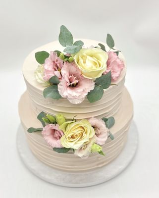 Torte mit gleichmäßiger Rillenoptik und Blumen (frontal gesetzt) zweistöckig