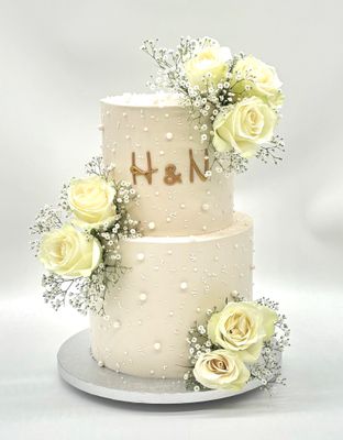Torte mit Perlendekoration und Blumen zweistöckig