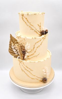 Torte mit blattgoldbesetzten Rissen im Zickzack und Trockenblumen (dreistöckig)