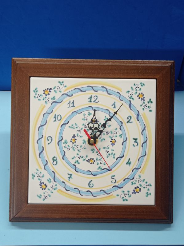 Orologio da parete con cornice in legno, in maiolica decorata, lato cm. 26.
