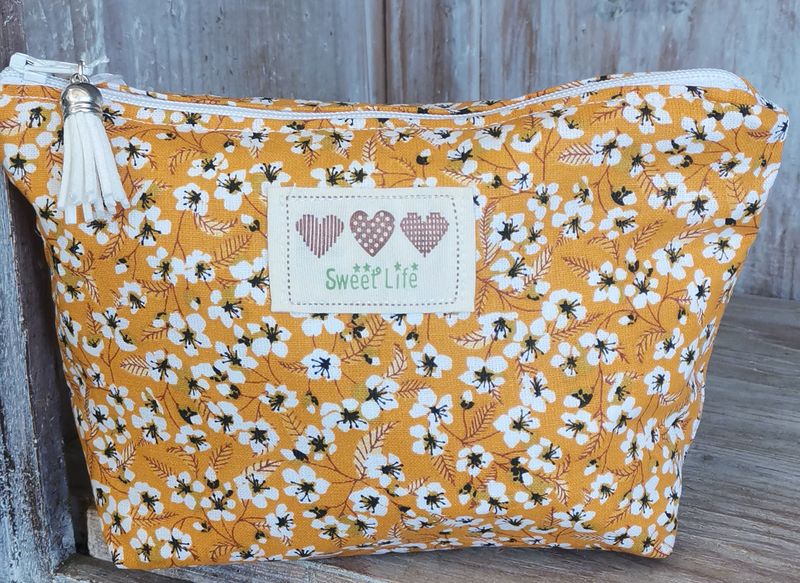 Trousse à maquillage jaune à  fleurs blanches
