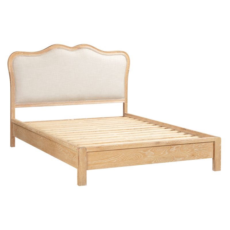 A wooden bed with white wash oak and a linen style padded headboard - side facing image.