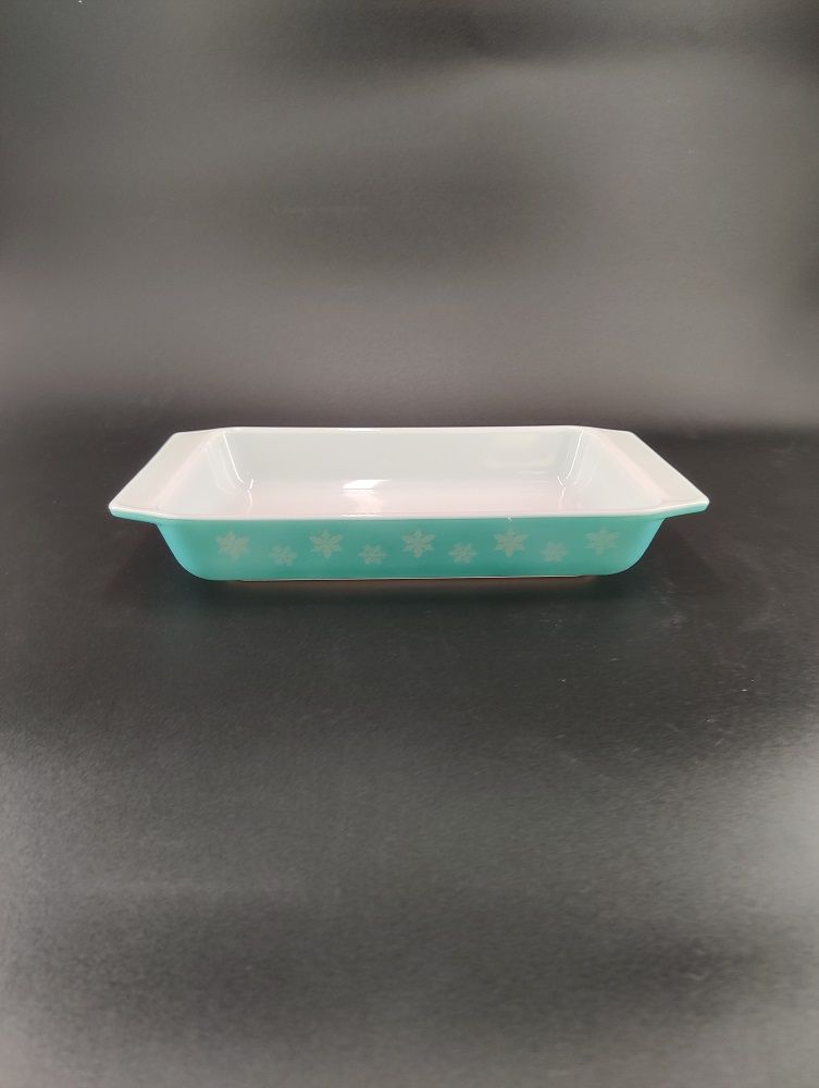 Two alternating snowflakes line the turquoise side of the dish.