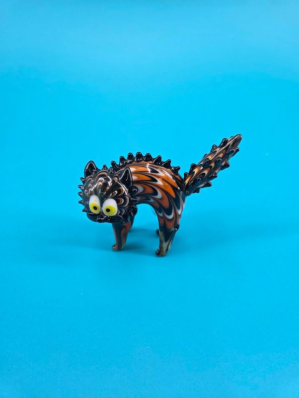 Cat figurine has huge eyes with yellow irises.