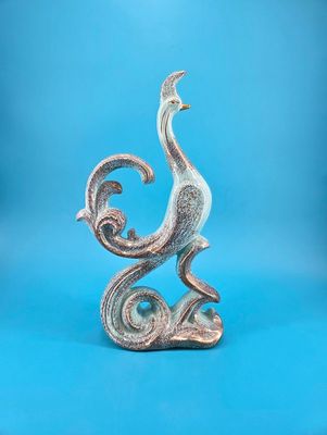 Figure is turquoise colored with gold speckles.