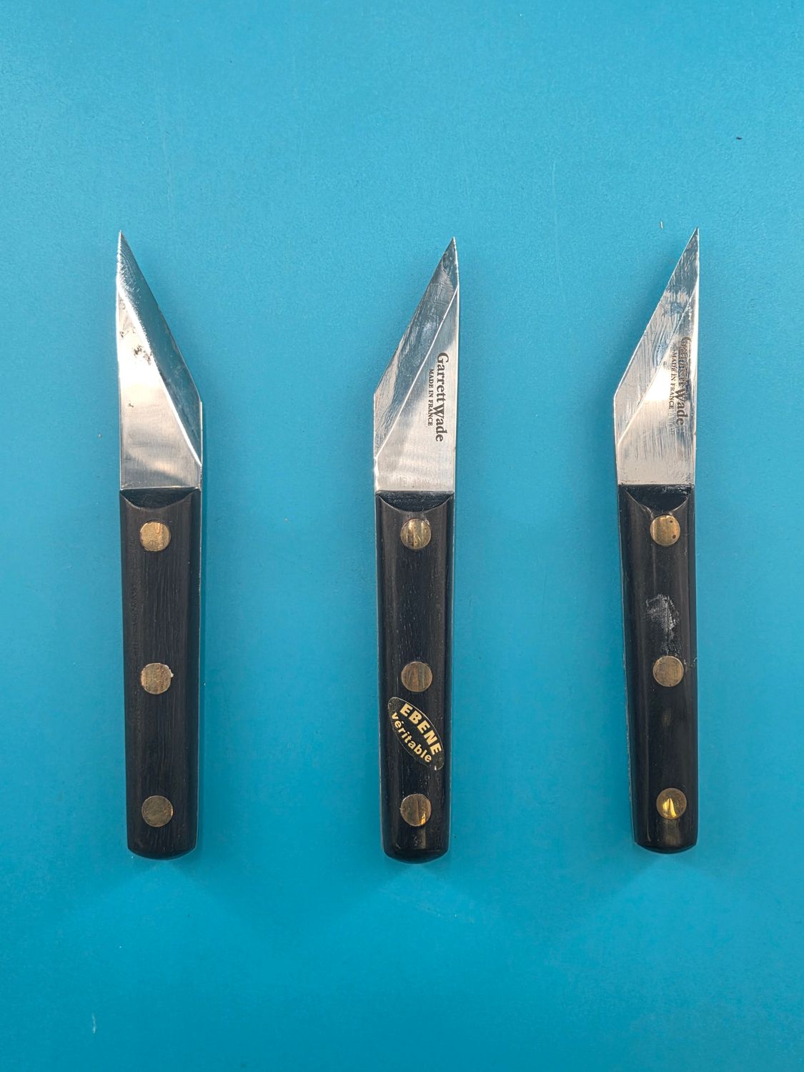 Knives aligned, showing off the beveled edges.