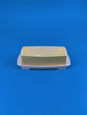 The butter dish has a yellow and white lid.