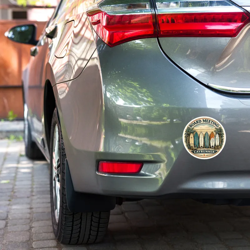 Cayrunner Board Meeting Sticker, 5.5 inch, applied to car bumper, showing surfboards and palm tree beach design.