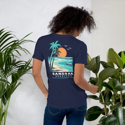 Woman among plants wearing the Cayrunner Salty Ways Unisex T-Shirt in navy, showing back palm tree beach design