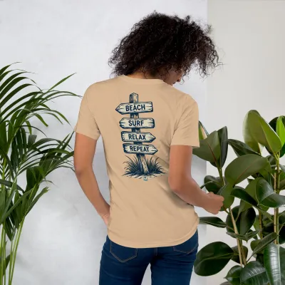 Woman wearing Cayrunner Find Your Coast unisex t-shirt in tan, back view showing "Beach Surf Relax Repeat" sign design.