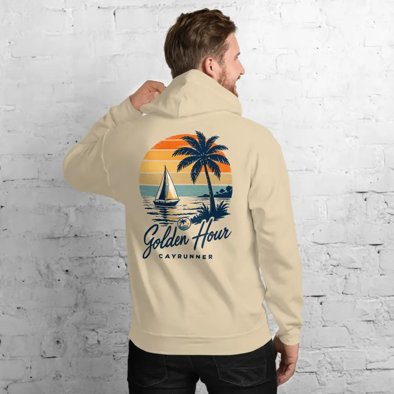 Man wearing Cayrunner Sunset Sail unisex hoodie in sand, back view showing "Golden Hour" sailboat and palm tree design.