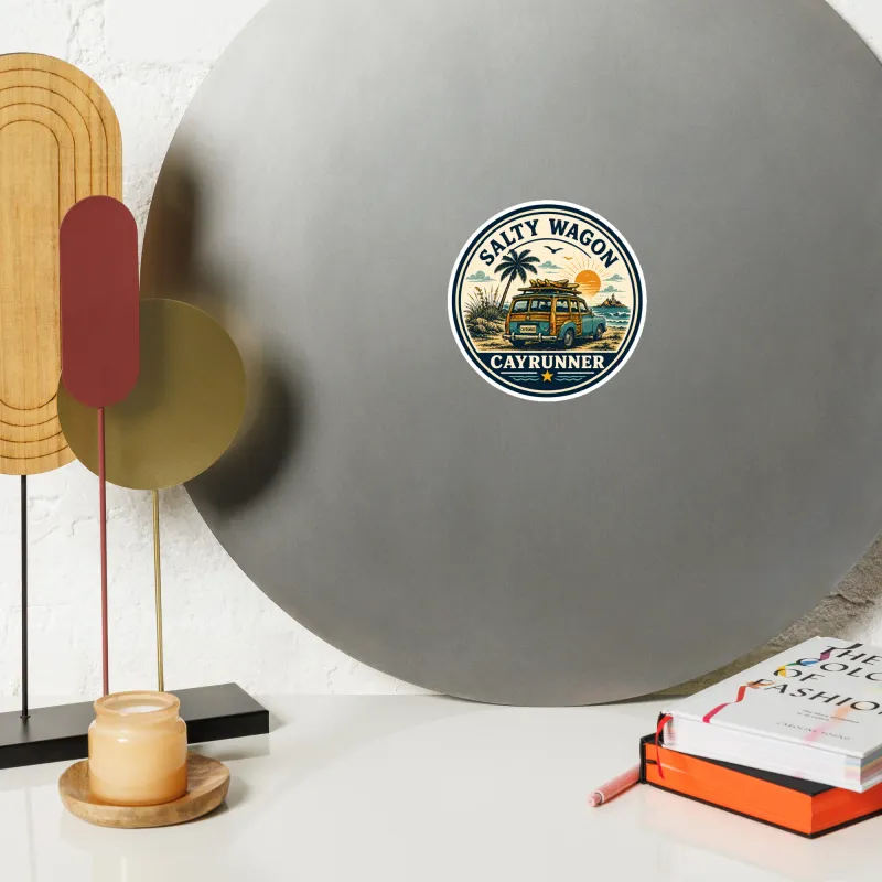 Cayrunner Salty Wagon flexible magnet on a round gray mirror, styled with decor, a candle, and books on a shelf.