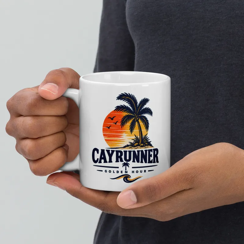 Person holding a Cayrunner Golden Hour coffee mug featuring a tropical sunset and palm tree design.