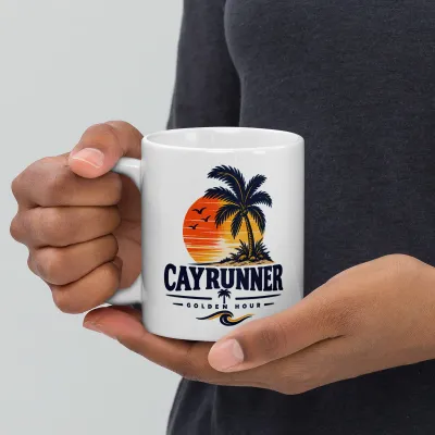 Person holding a Cayrunner Golden Hour coffee mug featuring a tropical sunset and palm tree design.