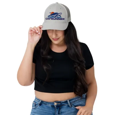 Woman in a black top wearing the silver gray Cayrunner Turtle Trucker Cap with embroidered sea turtle and sunset