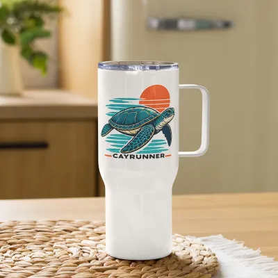 Cayrunner Sunset Turtle Travel Mug with Handle, on a woven mat on a wooden table