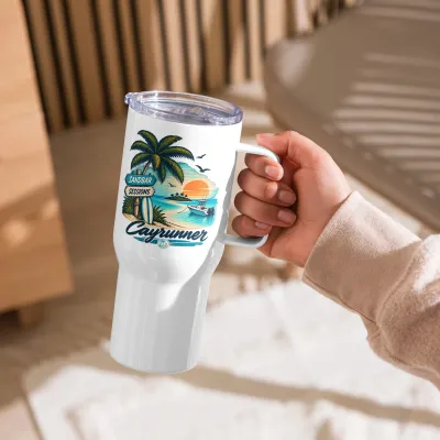 Cayrunner Tropical Sandbar Sunset Travel Mug with Handle, held by the handle in a sunlit room