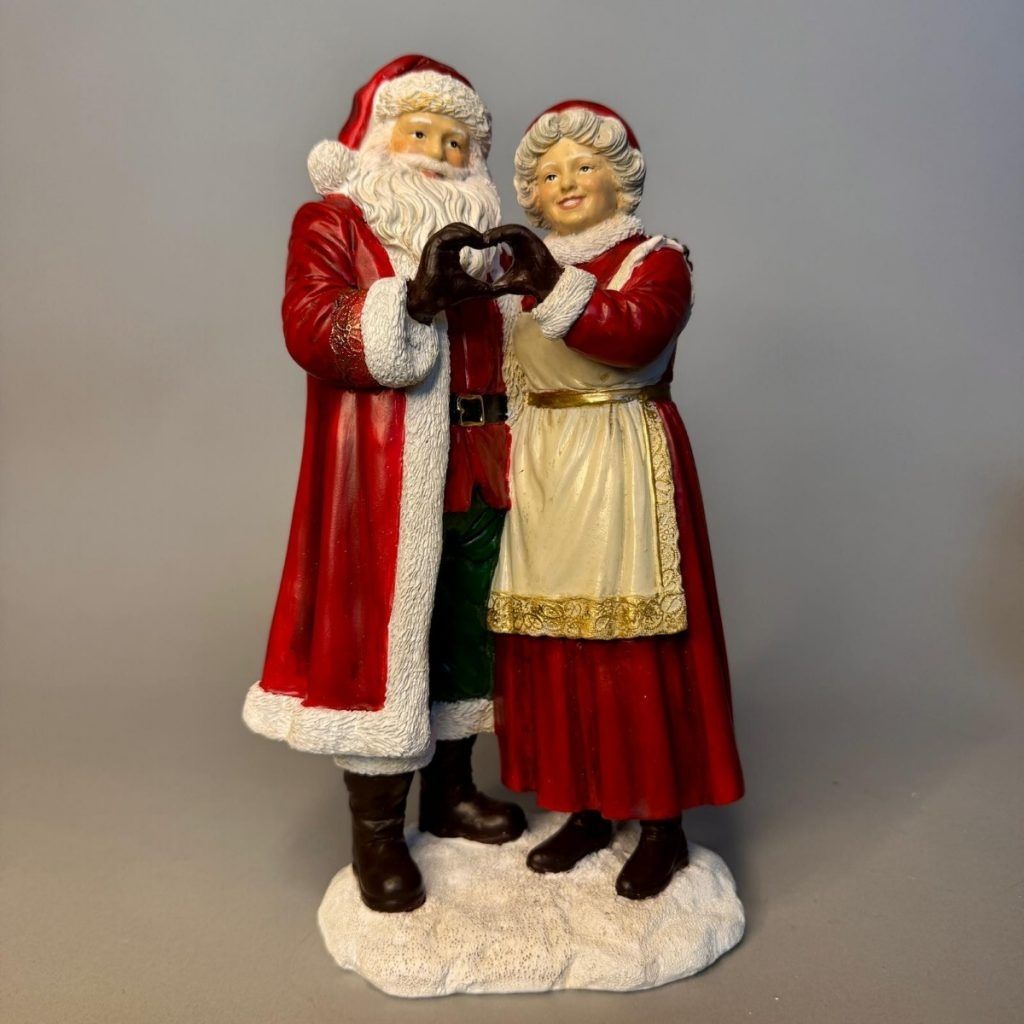 Mr &amp;Mrs Claus making love sign with hands