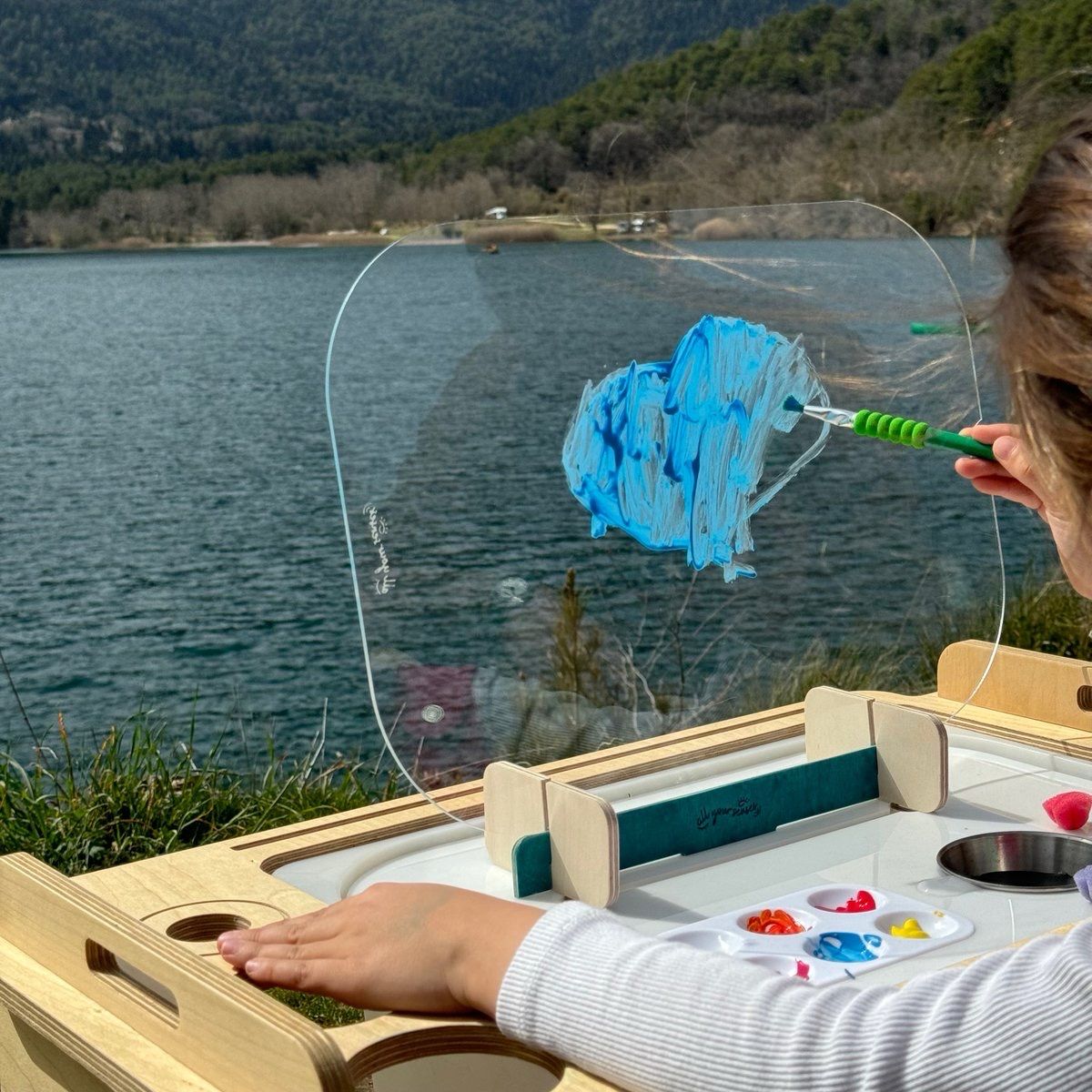 Παιδί ζωγραφίζει σε διάφανο πίνακα καβαλέτο πάνω σε κάδο Trofast