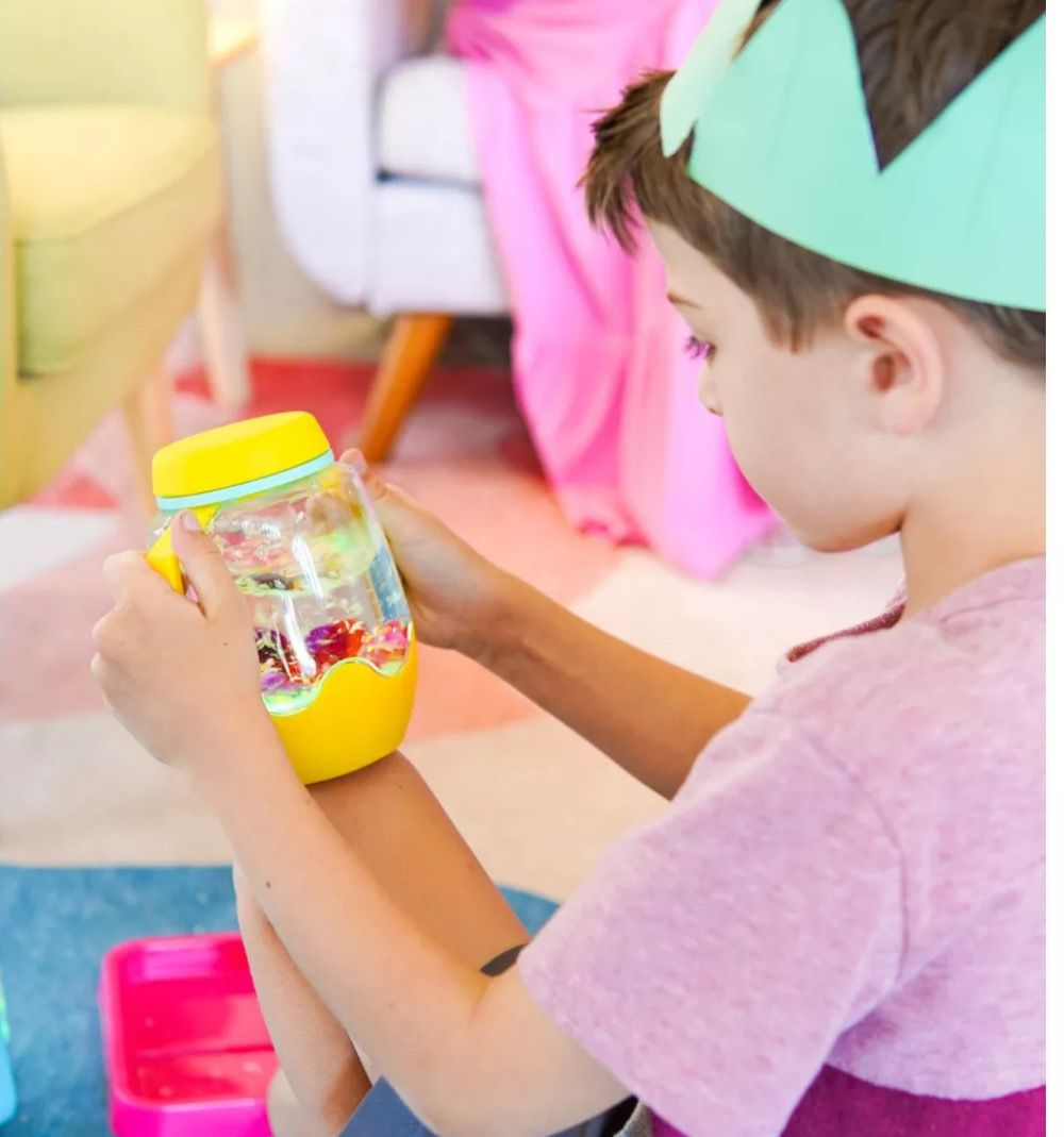 παιδι κρατα αισθητηριακο μπουκαλι στο δωματιο του