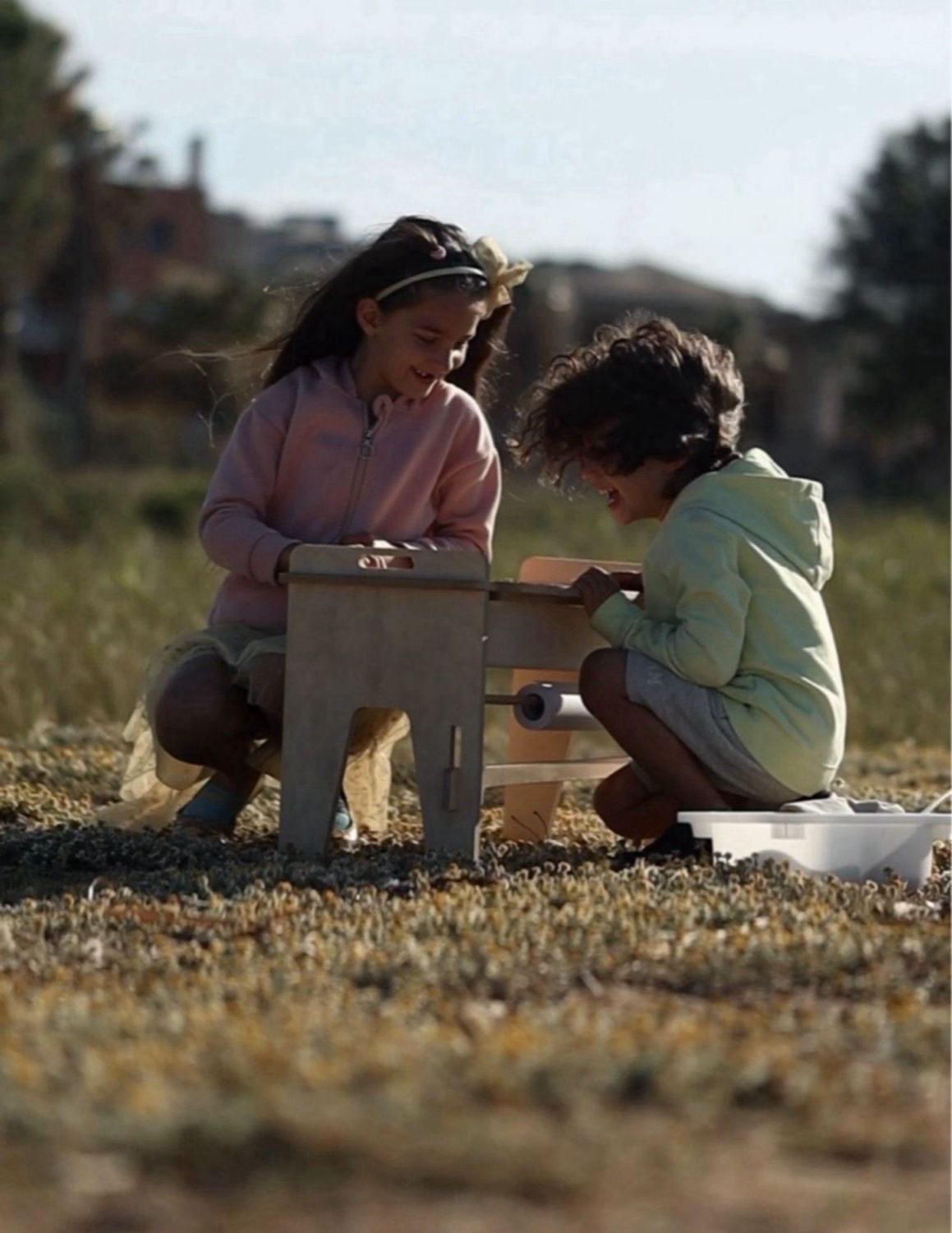 δυο παιδιά παίζουν στο τραπεζάκι δαπέδου messy play