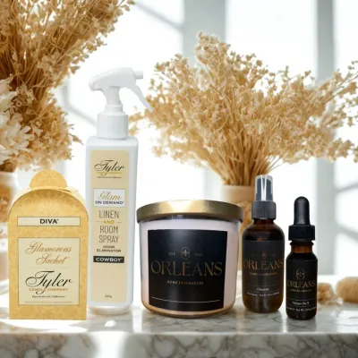 Luxury home fragrance products from Tyler and Orleans — room spray, candle, sachet, and scented oils styled on marble