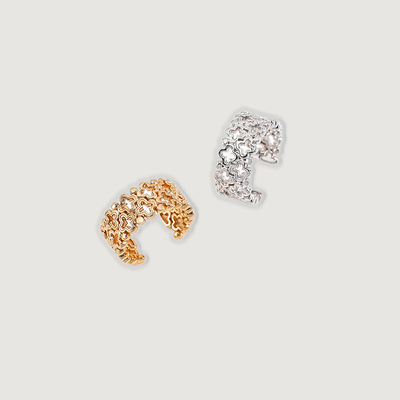 The image shows two floral-patterned cuff rings. One ring is made of gold-toned metal with a textured, abstract floral design. The other ring is made of silver-toned metal with a delicate, lace-like floral pattern. Both rings have a simple, open cuff design provides ajustable size to fit most finger size.